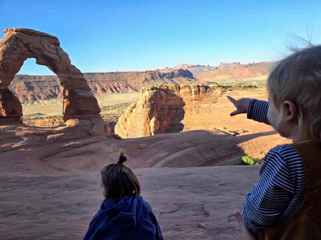 cooper and maverick at delicate arch in arches national park