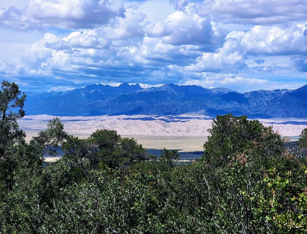 The dunes from afar on the Zapata Falls hike juxtaposing with the mountains beyond